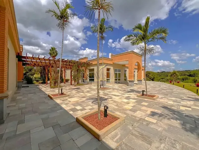 Área comum do condomínio com jardim e palmeiras