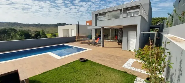 Fachada da residência com piscina e jardim